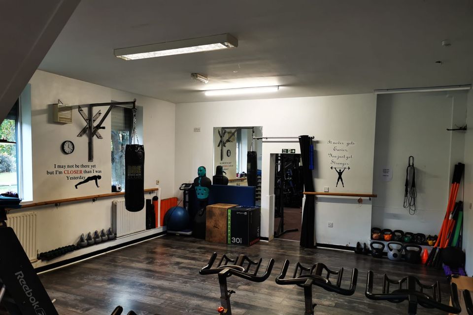 The studio, with spin bikes, a punch bag and boxing dummy, plyo boxes, kettlebells and a mirrored wall.